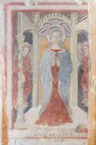 Affresco con figura femminile in preghiera e due angeli in abiti rossi in un'architettura stilizzata.