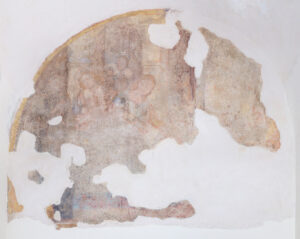 Affresco antico parzialmente deteriorato su parete curva con figure umane sbiadite.