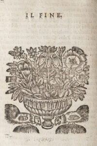 Pagina antica con scritta IL FINE sopra xilografia di vaso ornamentale con fiori e foglie.