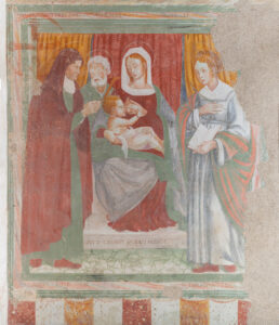 Affresco della Madonna che allatta il Bambino con due figure maschili a sinistra e donna con libro a destra.