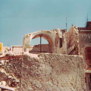 Rovine di edificio con arco in pietra e calce sotto cielo sereno.